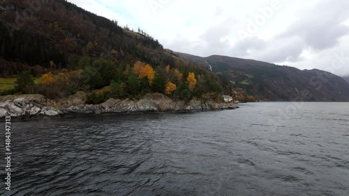 Scenic view from a boat journey between Bergen and Flåm, Norway, showcasing majestic fjords, rugged mountains, and calm waters under natural Nordic light — ideal for travel and nature themes.