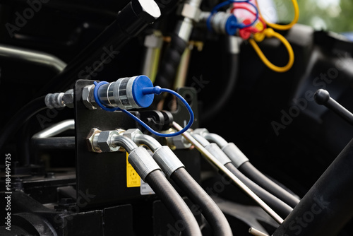 Close-up of hydraulic hoses and connectors on machinery equipment.