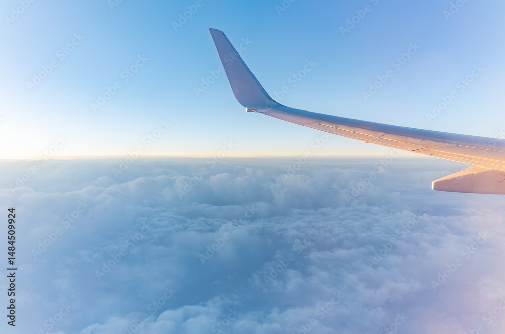 Obraz premium View from the airplane window at a beautiful cloudy sky and the airplane wing
