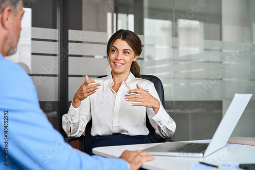 Female executive speaking to colleague working at office corporate meeting. Busy happy business woman professional bank manager lawyer attorney consulting client on finances management.