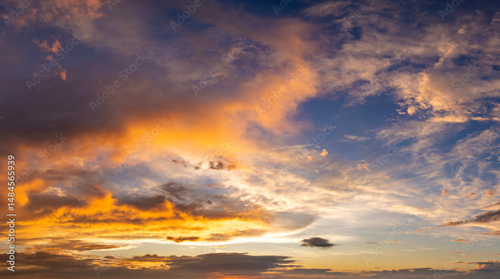 Fototapeta premium Bright sunset with setting sun behind vivid orange and yellow clouds