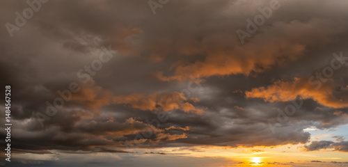 Fototapeta Naklejka Na Ścianę i Meble -  Colorful sunset sky with setting sun behind vivid orange and yellow clouds