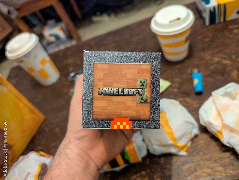 Fototapeta premium France, 25 March 2025 : Minecraft themed merchandise alongside food and drinks on table.