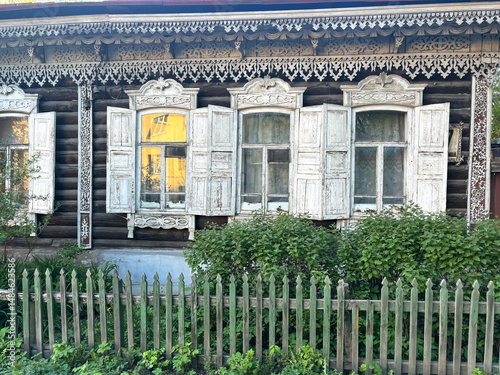 Old Russian wooden windows. Old Russian wooden house with carved architraves