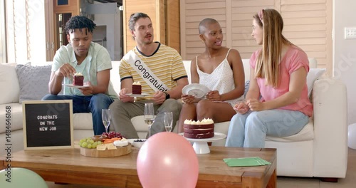 Friends celebrating new job with cake and snacks at home, enjoying together