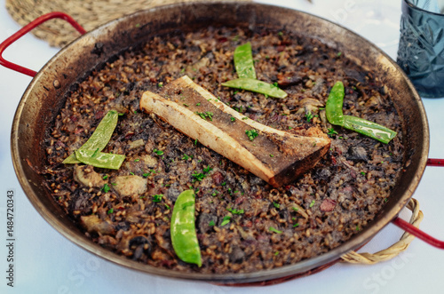 Deliciosa paella con tuétano y guisantes