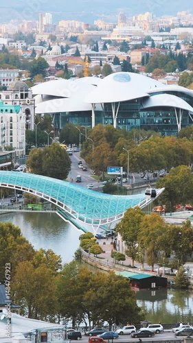 Tbilisi, Georgia. Aerial View, Cityscape View Of Kura Mtkvari River Under Pedestrian Bridge Of Peace, Justice House Back From