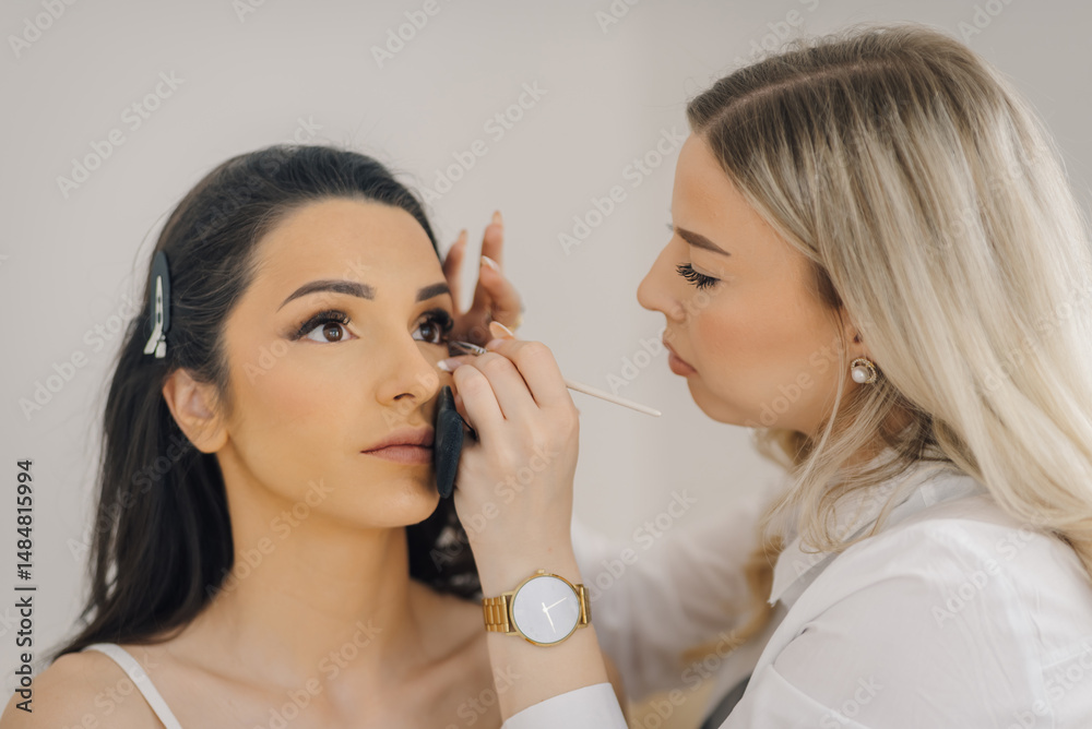 Professional makeup artist applying makeup to a client's eye Professional makeup artist applying makeup to a client's eye