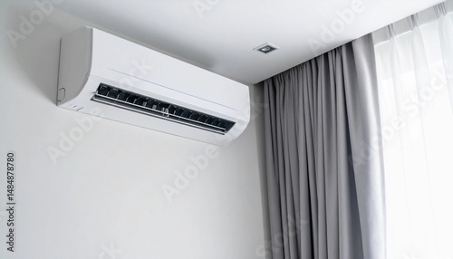 air conditioner unit mounted on a white interior wall, with gray curtains partially 