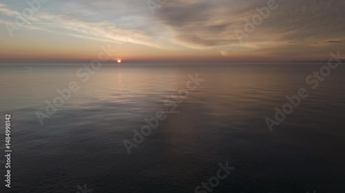 Aerial drone video of the Adriatic Sea at sunrise off Porto Potenza, Italy. Peaceful flyby capturing calm waters, golden reflections, and serene coastal beauty.