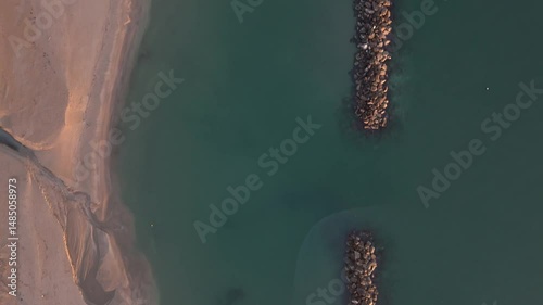 Aerial drone video of the Adriatic Sea at sunrise off Porto Potenza, Italy. Peaceful flyby capturing calm waters, golden reflections, and serene coastal beauty.