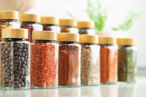 Fototapeta Naklejka Na Ścianę i Meble -  Many different aromatic spices in jars on table indoors, closeup