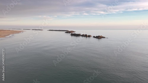 Aerial drone video of the Adriatic Sea at sunrise off Porto Potenza, Italy. Peaceful flyby capturing calm waters, golden reflections, and serene coastal beauty.