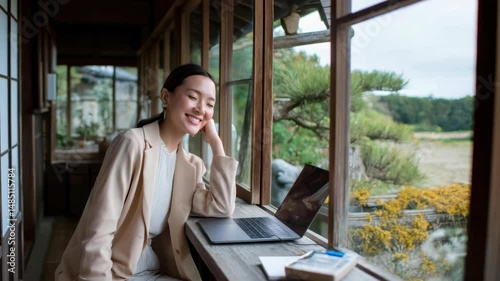 古民家で自然を眺めながら仕事をするアジア人女性のリモートワーク風景