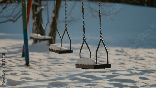Obraz na płótnie Snowy playground swings under winter sunlight w salonie