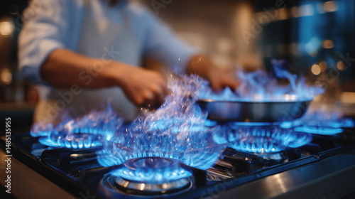 Wallpaper Mural Modern kitchen with stainless steel appliances, close-up of blue flames on gas stove as a couple prepares a warm, hearty meal Torontodigital.ca