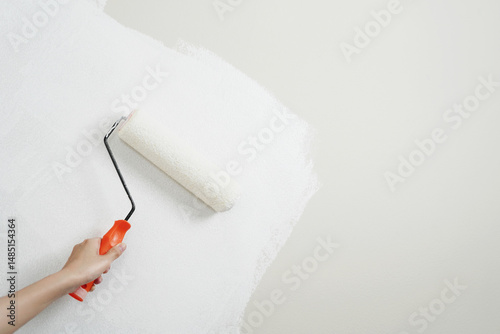 Roller Brush Painting, Worker painting on surface wall Painting apartment, renovating with white color paint. Leave empty copy space white to write descriptive text beside