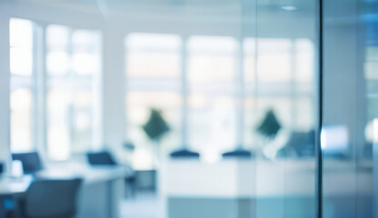 Blurred office interior with desks chairs and windows showing bright daylight.