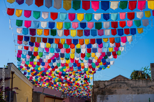Colorful flags in the sky for the Sant'Efisio Festival in the town of Pula, Sardinia, Italy