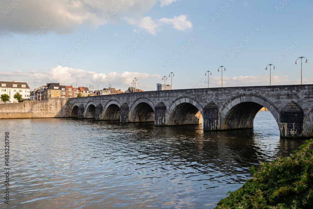 Fototapeta premium Maastricht, Netherlands - September 17, 2024: View of the old stone bridge on the city's waterfront