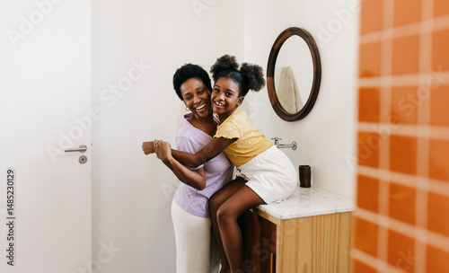 Happy mother and daughter having a happy morning routine in their home