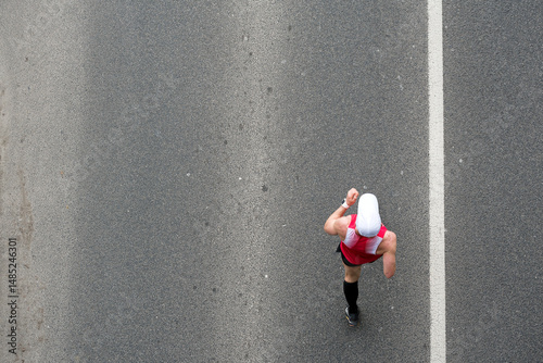 Race walking man against asphalt, top view