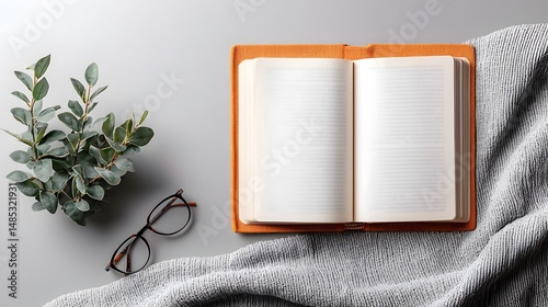 Open Book on Linen Fabric with Reading Glasses and Plant photo