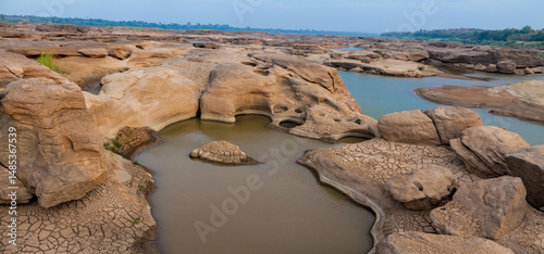Mae Khong riverbed at Sam Phan Bok canyon in Thailand on border with Laos. Rock holes scattered over the river bank in different shapes. Mekong river bed South East Asia nature environment landscape