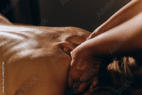 Obraz na plátně Close-up of a woman receiving a Thai back oil massage in a candlelit spa, highlighting skin details and an intimate atmosphere