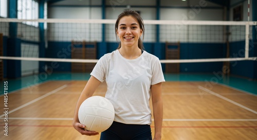Female volleyball athlete smiling softly with volleyball in indoor court 