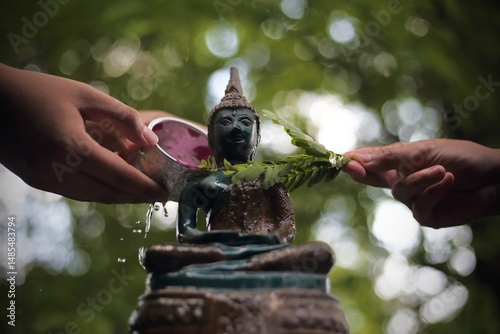 Pouring water on Buddha images and sacred objects in the home during the Songkran Festival for Thai people
