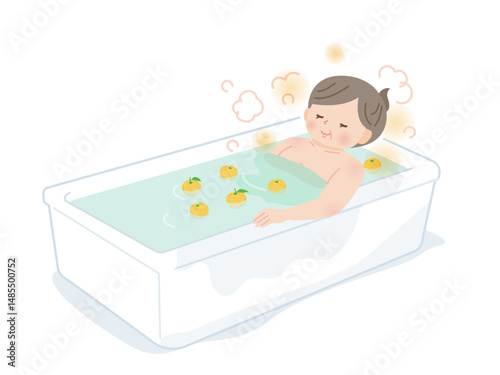 柚子風呂に入ってのんびりする中年女性