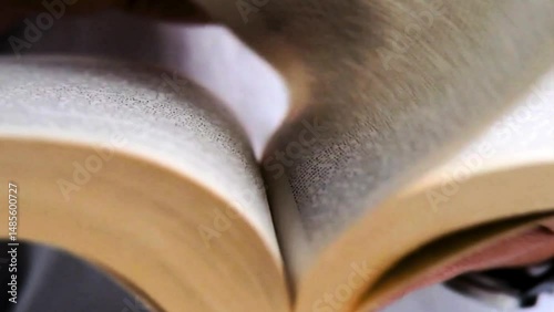 video of a person's hand turning the pages of a book to read and study
