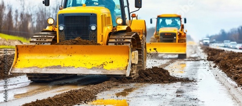 Heavy Machinery Road Construction: Bulldozers Working on a Wet, Muddy Road