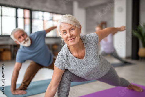 Active senior woman does yoga pose with friends during group fitness class in studio for healthy lifestyle wellness activity