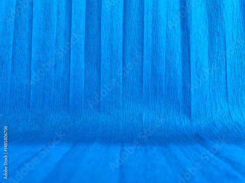 Abstract background made of blue crepe paper with vertical folds and texture