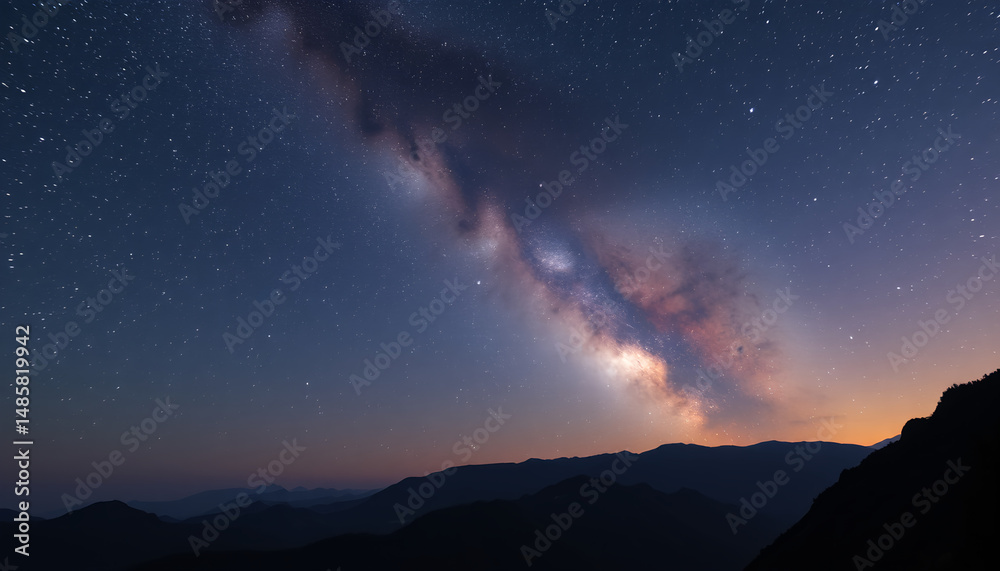 Naklejka premium Milky Ways ethereal glow over dark mountain silhouettes at twilight