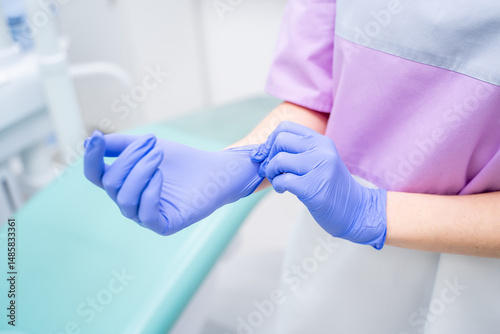 A Medical Professional Donning Protective Gloves in a Clinic Setting for Patient Care