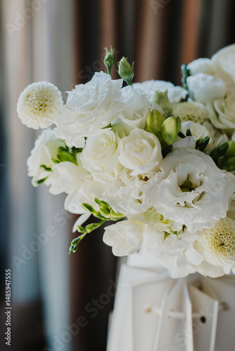 Delicate wedding bouquet of white flowers Freesia, Roses in a morning sunlight.