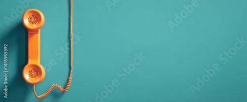 The bright orange telephone receiver against a teal background.