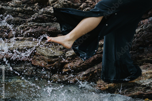 Close up young woman play with the clear water by the sea.