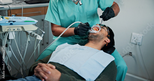 Man, patient and dentist cleaning mouth with tools for bacteria or germ removal at orthodontist. Male person, client or teeth surgeon with suction for tooth extraction, dental or oral care at clinic