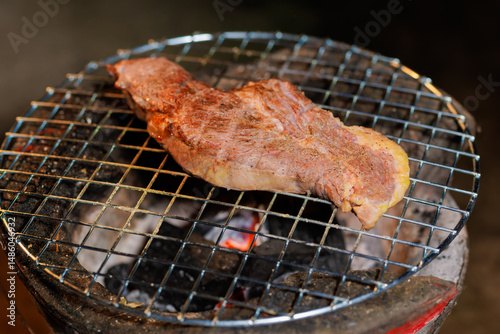 A perfectly grilled beef steak rests on a hot barbecue grill, ready to be served at a lively outdoor party or festive gathering.