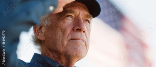 Elderly man saluting with flag in background, showing respect