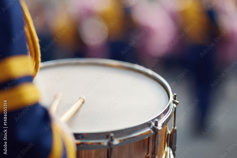 Obraz premium Marching band member playing snare drum with focus on drumsticks