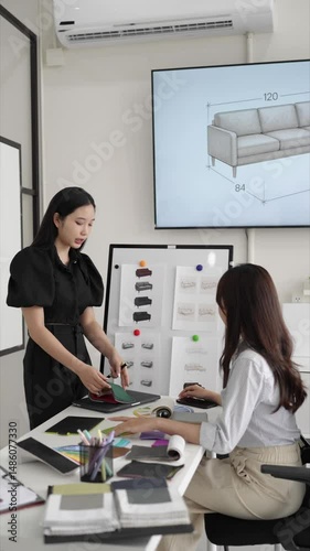 Vertical shot of interior consultation with designer pointing at board