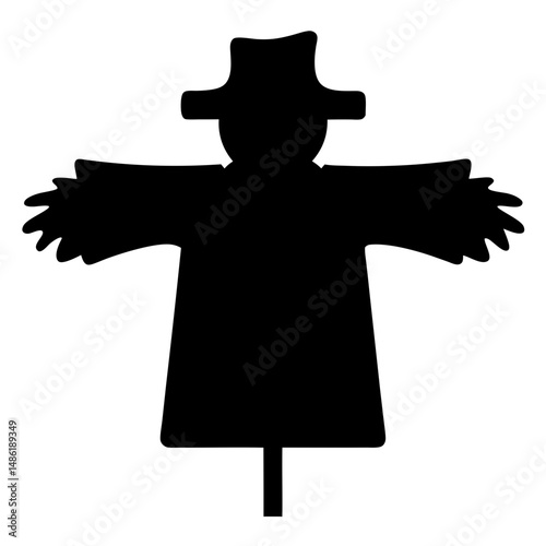 A Silhouetted Scarecrow with Hat Stands Guard in the Field on Stick