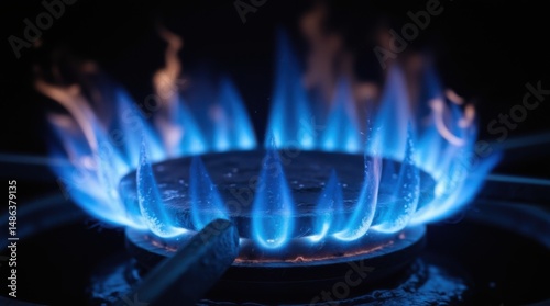 Blue flame produced by gas. Gas burner against a dark backdrop. Ignition of natural gas in stove burner, close-up view.