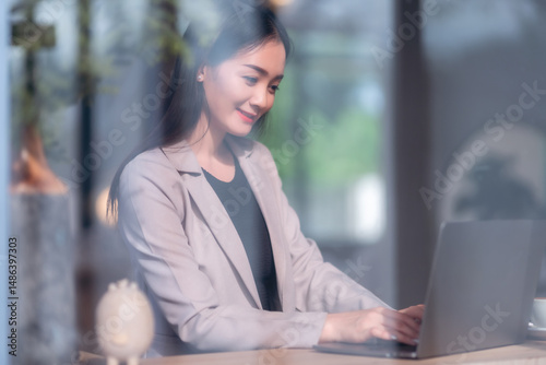Asian freelance people business female talking making using casual working with laptop computer and coffee at home in the living room indoors artificial rose bouquet of red and pink roses rose vase