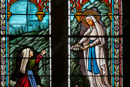 Stained glass (19th century) of Apparition of the Virgin Mary, Our Lady of Lourdes or Notre Dame de Lourdes to Bernadette Soubirous.